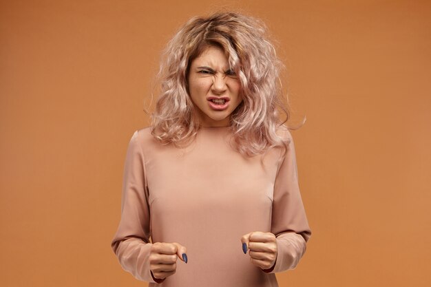 Free Photo enraged furious young woman with voluminous hair clenching fists and roaring, expressing her anger