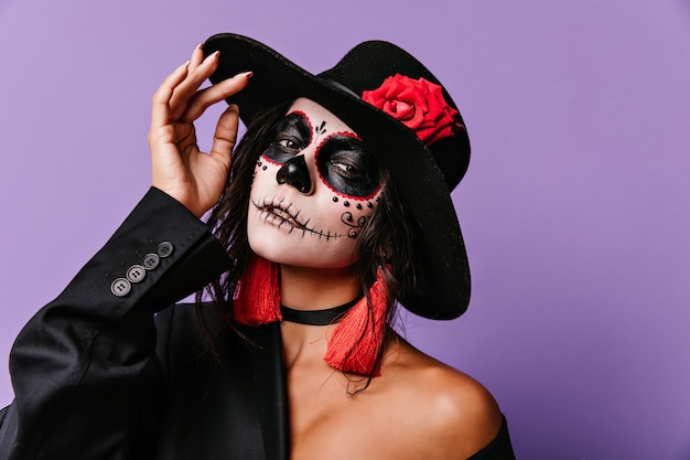 Free photo enthusiastic latin lady in muertos outfit. indoor photo of inspired caucasian girl wears zombie costume in halloween.