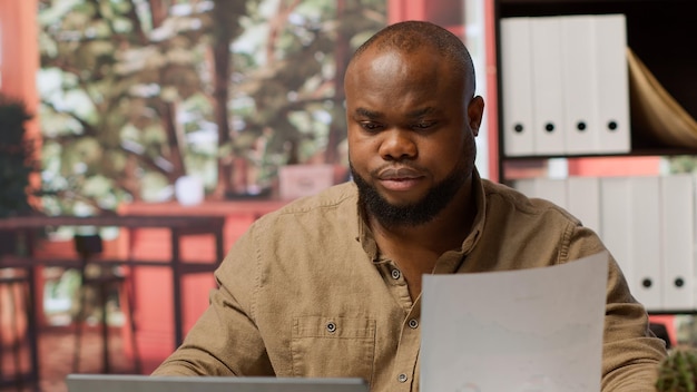 Free photo entrepreneur taking notes and managing business analytics at his home office