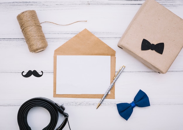 Envelope with paper near box, threads and leather strap