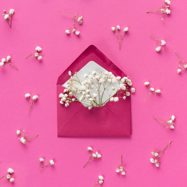 Envelope with small flower branches on table