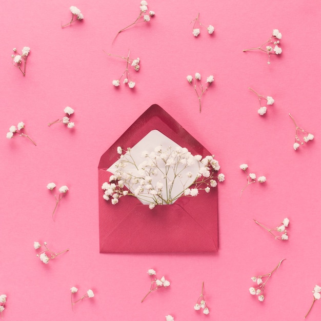 Envelope with white flower branches on table