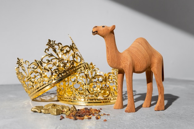 Free Photo epiphany day gold crowns with camel figurine and raisins