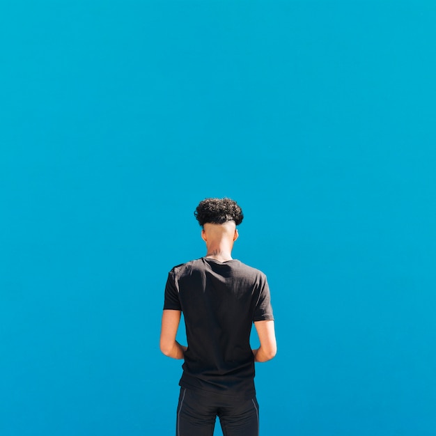 Free photo ethnic athlete in black sportswear on blue background