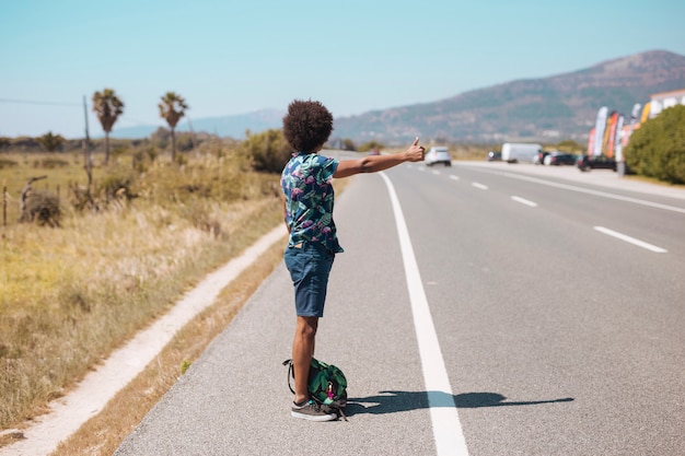 Ethnic male hitchhiking on roadside