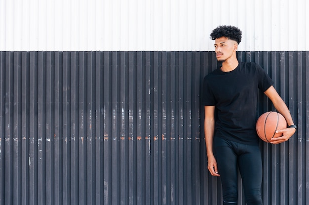 Ethnic man with basketball looking away