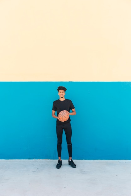 Ethnic player with basketball on street