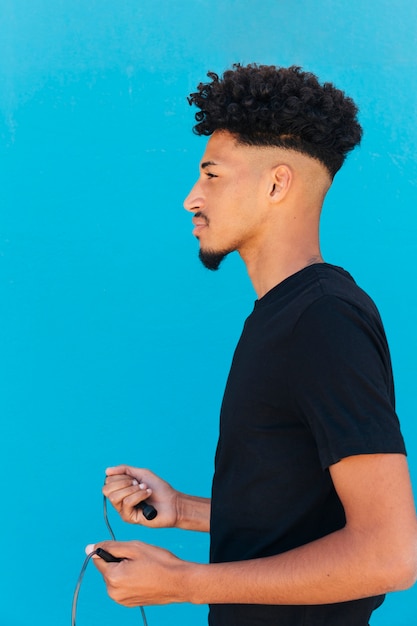 Free photo ethnic sportsman with curly hair preparing to jump