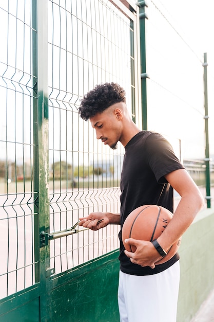 Ethnic young man opening basketball court 