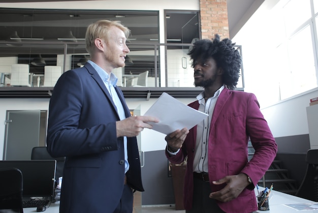 European and African-American business partners discussing a contract during a business meeting