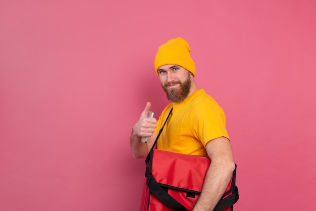 European bearded delivery man with box with food on pink