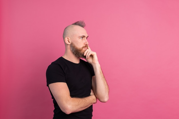 Free Photo european thoughtful man in studio on pink background