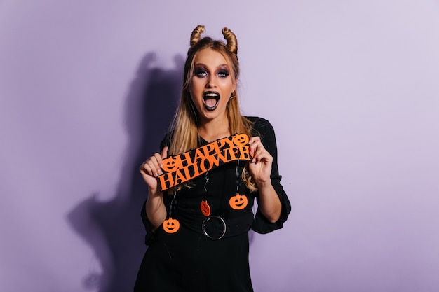 Free Photo european young woman with funny hairstyle posing at party. good-looking girl celebrating halloween.