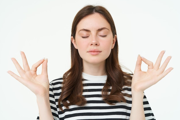 Free photo everything under control young woman meditating standing in zen yoga pose keeps calm posing with