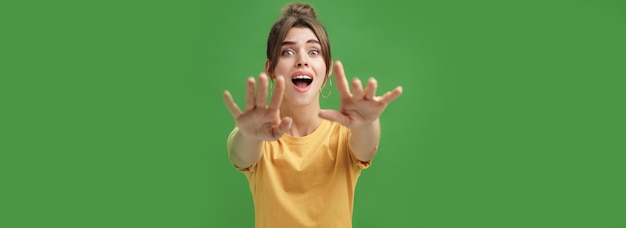 Free Photo excited and addicted googlooking young woman reaching hands forward to camera with reckless look wanting grab something she desire seeing thing she wanted for long time over green background