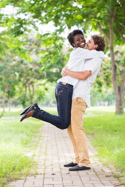 Excited African woman jumping to hug boyfriend