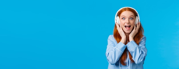 Free photo excited and amused attractive caucasian redhead woman in pyjama screaming from fascination and amaze