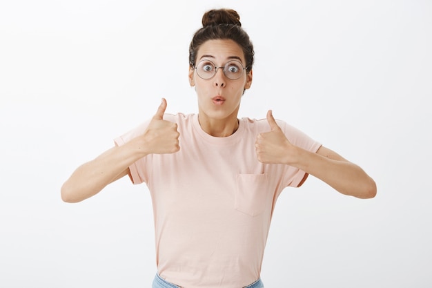 Free photo excited beautiful girl with glasses posing against the white wall