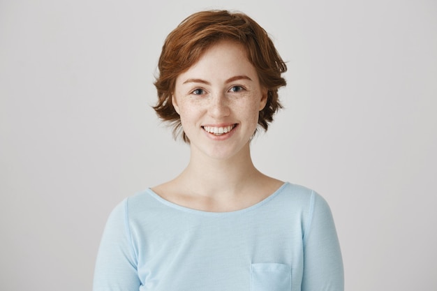 Excited beautiful young woman smiling hopeful at camera