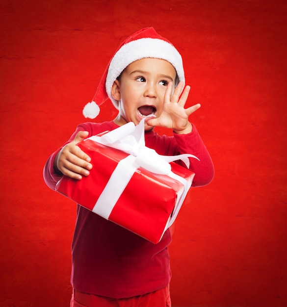 Free Photo excited boy holding a gift with white ribbon