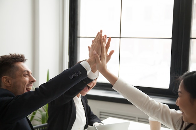 Free Photo excited colleagues giving high five reaching goal