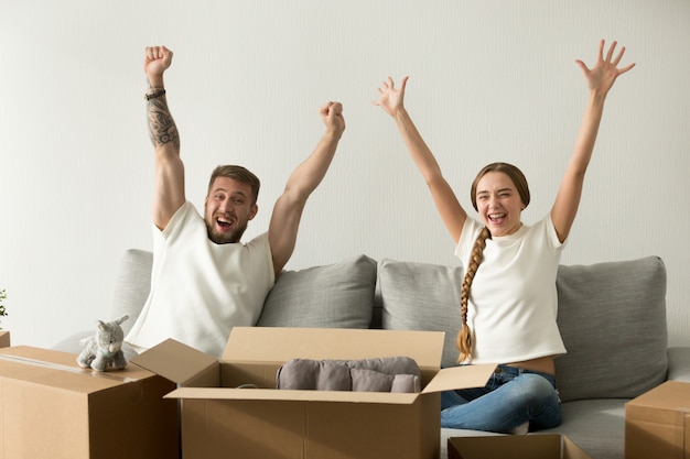 Free photo excited couple raising hands happy to move to new house