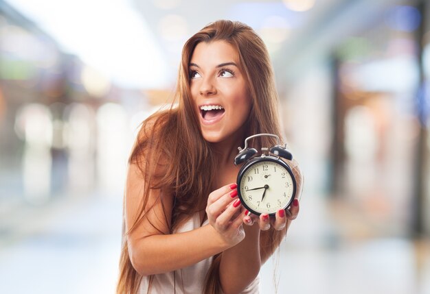 Excited girl holding clock