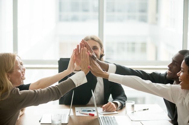 Free Photo excited happy multiracial business team giving high-five at office meeting