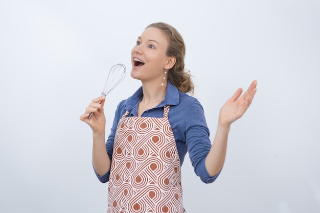 Free photo excited housewife using whisk as microphone