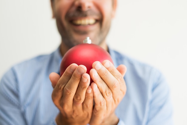 Free Photo excited man making wish while holding red bauble in hands