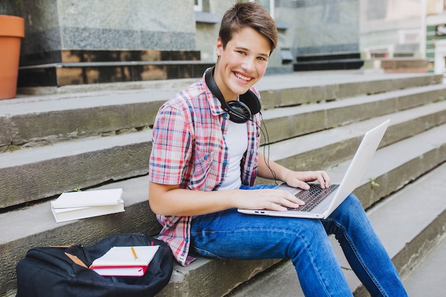 Excited man with gadgets on stairs