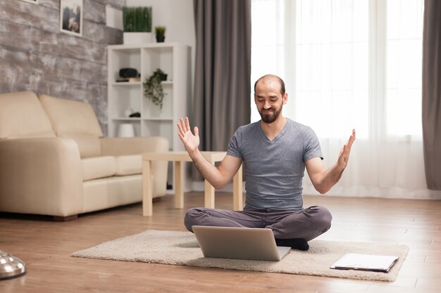 Excited man with hands raised in front of computer during quarantine.