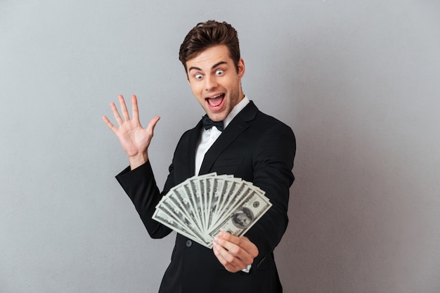 Excited screaming man in official suit holding money.