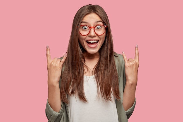 Excited student posing against the pink wall