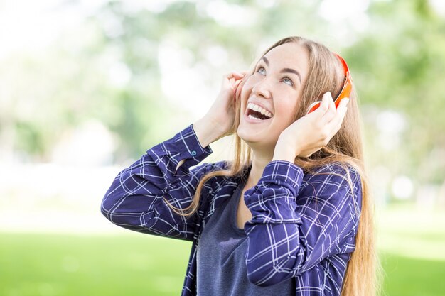 Excited teenage girl listening to audiobook