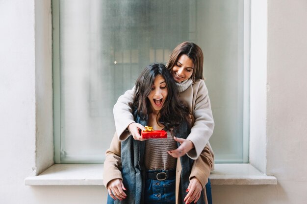 Excited woman getting present from girlfriend