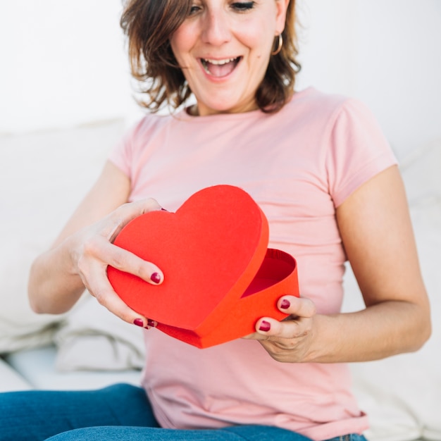 Free photo excited woman opening heart-shaped box