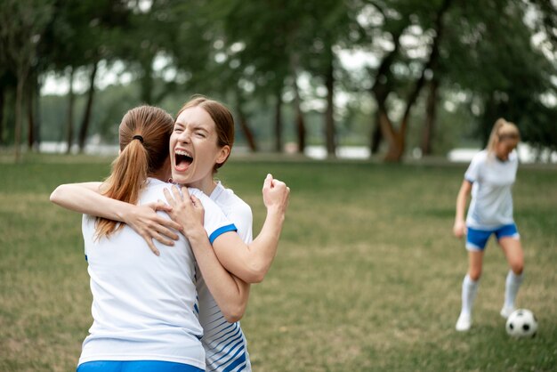 Excited women hugging outdoors