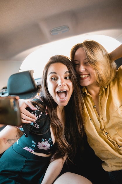 Free photo excited women taking selfie in car