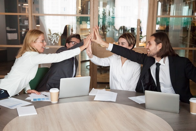 Free photo excited work team giving high five celebrating shared achievement