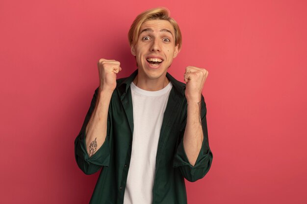 Excited young blonde guy wearing green t-shirt showing yes gesture