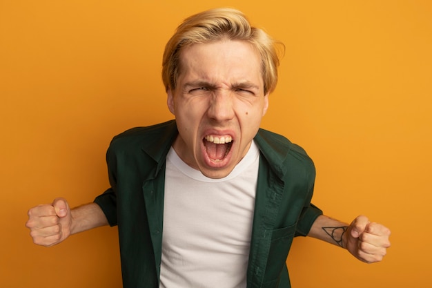 Free photo excited young blonde guy wearing green t-shirt showing yes gesture