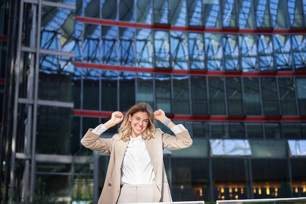 Free Photo excited young businesswoman celebrating triumphing feeling free and happy posing in the city near of