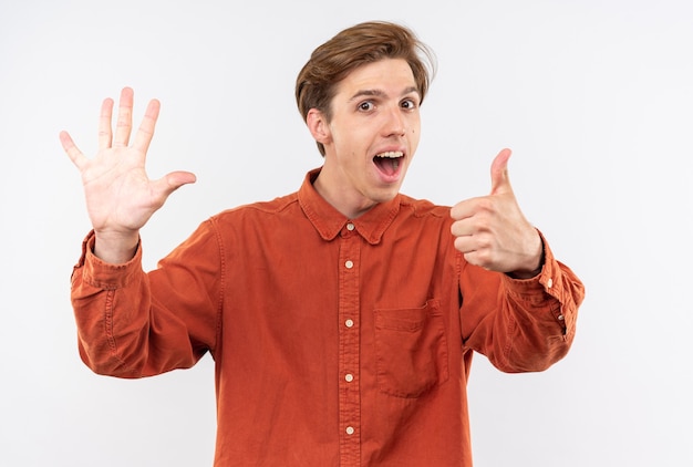 Excited young handsome guy wearing red shirt showing differents gestures