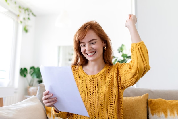 Free photo excited young woman hold paper letter feel euphoric receiving job promotion or tax refund from bank happy woman reading paperwork document smiling of good pleasant news getting student scholarship