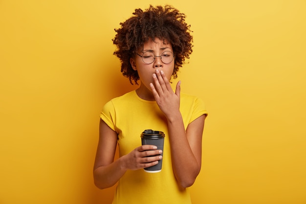 Exhausted sleepy female student tries to complete task before deadline