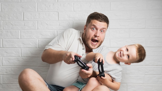 Free Photo exited father and son playing at home