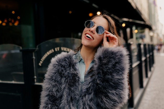 Exited stylish lady in trendy outfit in the city.