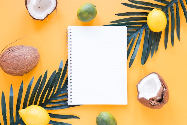 Free photo exotic fruits with blank notebook on table