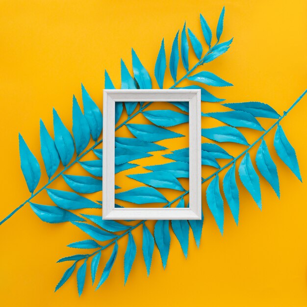 Exotic tropical leaves and empty frame on yellow